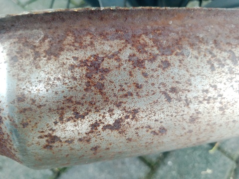 Close up of the rusty exhaust of a motorcycle