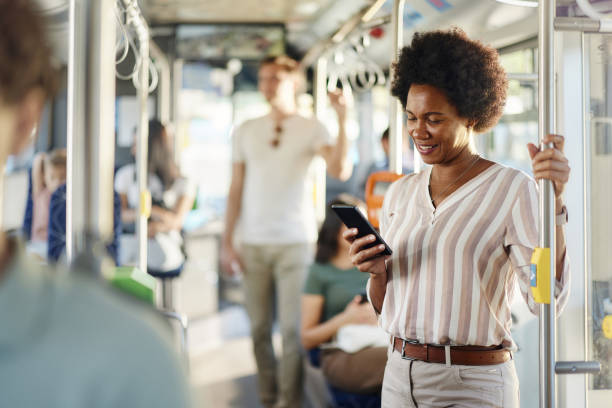 istock Happy African American woman using cell phone in a bus. 2129362940
