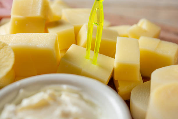 Butter board preparing, spreading butter and cottage cheese topping over wood serving board, closeup