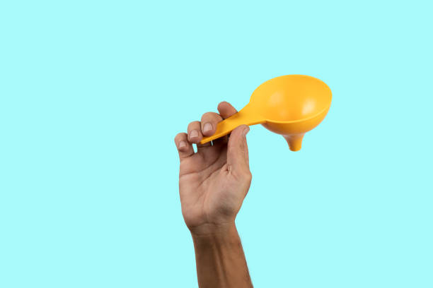 istock Male hand holding white earbuds on cyan background. 2129372236