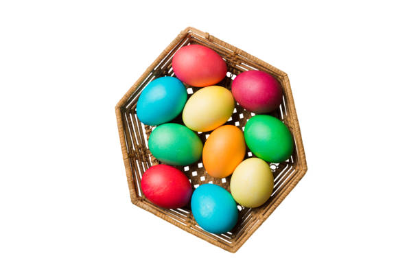 Basket of colorful Easter eggs isolated on white background. Easter basket filled with colored eggs top view holiday concept .