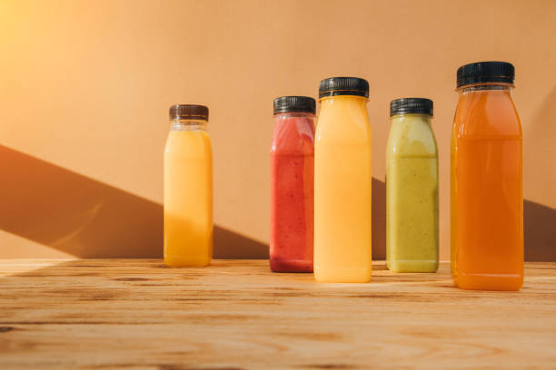 istock Fruit and vegetable smoothies in transparent plastic bottles. Red, green, orange smoothies on a wooden table. The concept of healthy eating 2129400893