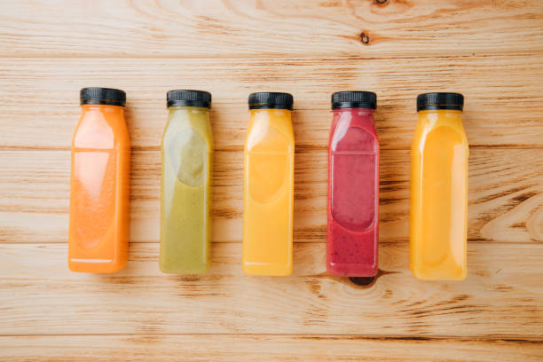 istock Fruit and vegetable smoothies in transparent plastic bottles. Red, green, orange smoothies on a wooden table. The concept of healthy eating 2129401453