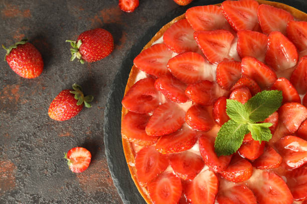 istock Tray with strawberry tart on dark textured table 2129403552