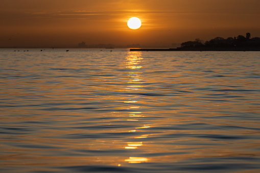 Sun is setting over by the sea.\nMarmara sea - Istanbul - Turkey.