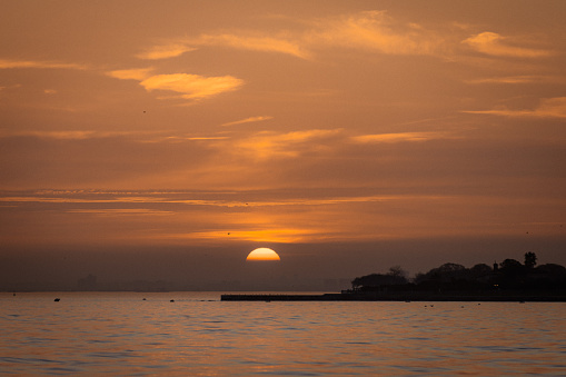 Sun is setting over by the sea.\nMarmara sea - Istanbul - Turkey.