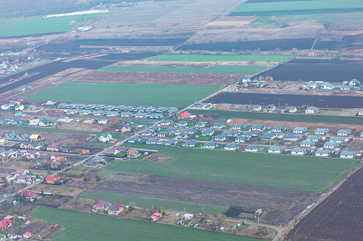 Aerial view of the village in the middle of agricultural fields and meadows