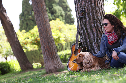 Owner with Cocker Spaniel and Guitar amongst trees