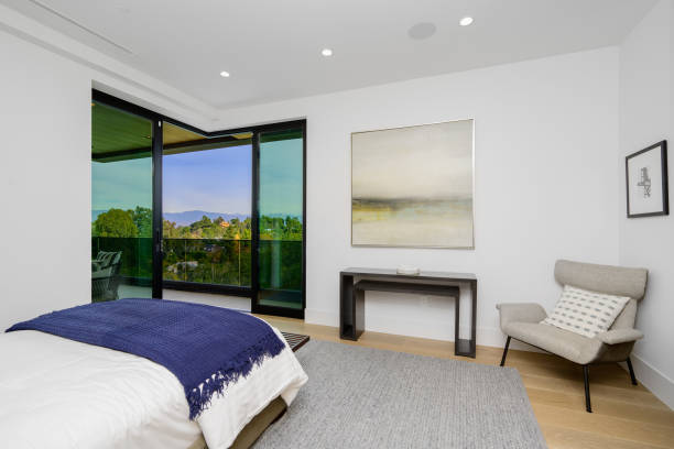 istock Spacious bedroom with large bed and city view balcony. 2129437225