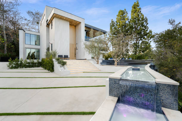 istock Luxurious white house with a pool, surrounded by trees, during sunset. 2129439796