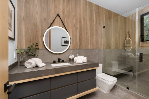 istock White toilet near a sink under a round mirror. 2129439797