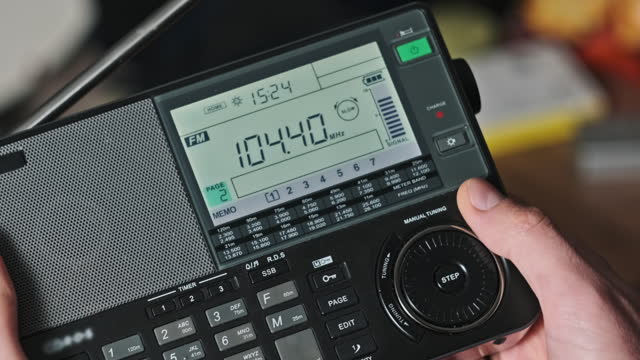 Man Searching Frequency of Radio Stations on Modern Radio with Digital LCD Scale