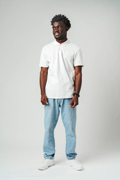 istock Young African Man Standing in White Shirt on Gray Background. 2129458961