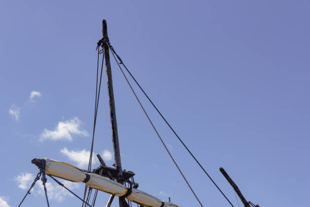 Old ship masts with the sky in the background.