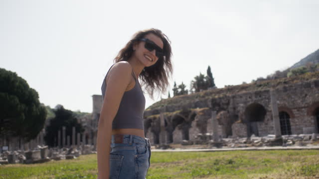 Portrait of young tourist woman in a historical archeological ancient town ruins.