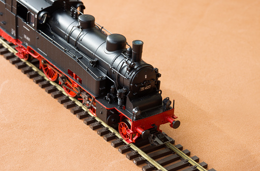 Toy locomotive and railroad with selective focus effect. Model of a locomotive on a dark background.
