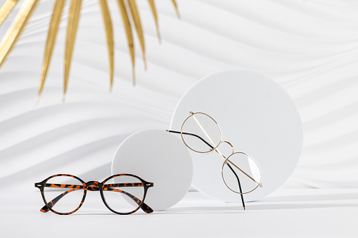 Two pairs of eyeglass frames on white background. Minimalism, eyewear fashion concept. Trendy eyeglasses still life in minimal style. Optic store discount, sale, promotion. Copy space