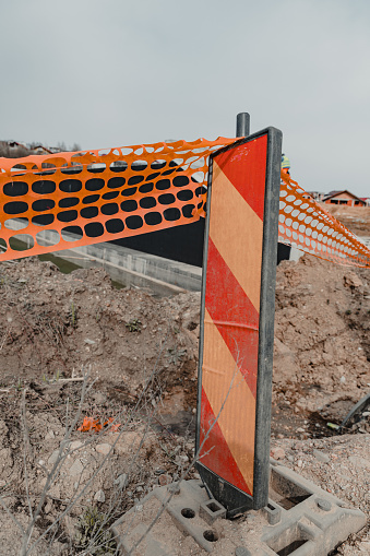 Under Construction fence mesh and barrier sign in orange colour.