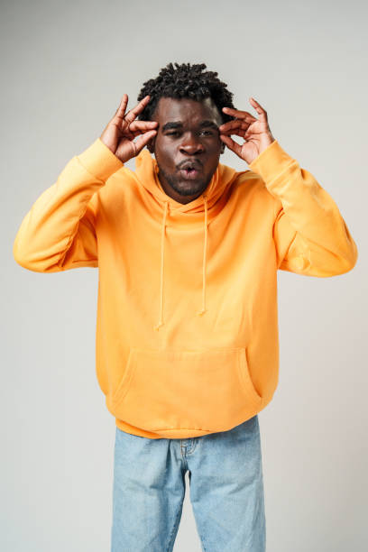 istock African Man in Yellow Hoodie Holding Head and Smiling 2129476830