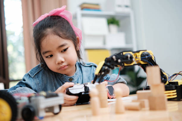 istock A young girl is playing with a remote control a robot 2129480027