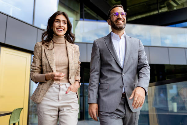 istock Cheerful Colleagues Exiting a Modern Office Building on a Bright Afternoon 2129481560