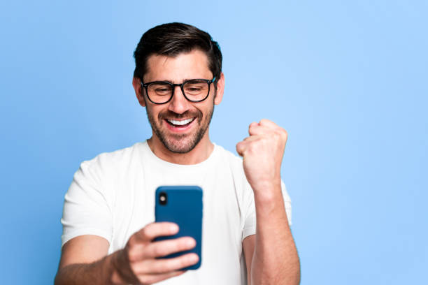 istock Excited man celebrating success with smartphone 2129486223