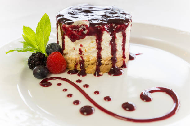 cake with berries, blackberries, raspberries and blueberries with a reduction of raspberry syrup and mint leaves