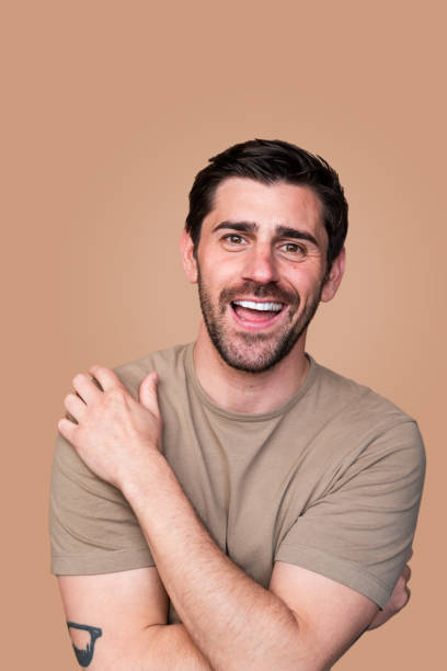 istock Happy young man smiling with arms crossed 2129496777