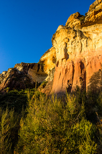 The steep impassable golden and ochre colored sandstone cliffs in the Golden Gate Highlands National Park of South Africa.