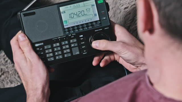 Man Searching frequency of radio stations on Modern Radio With Digital LCD Scale