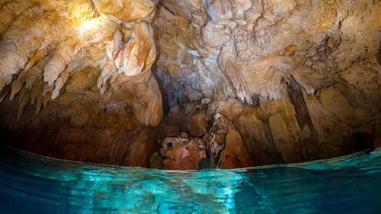 The bluish-turquoise water in a cave illuminated by soft light