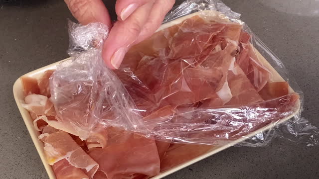 Unwrapping tray with prosciutto ham in it