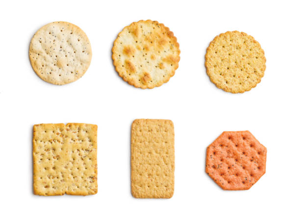A selection of various crackers neatly placed in a straight line on white background.