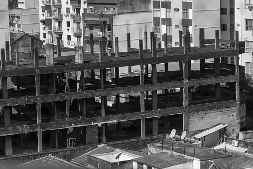 A monochrome shot of a large construction site with numerous unfinished buildings.