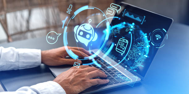 istock Man hands typing on laptop, chat bot hologram on computer screen 2129507509