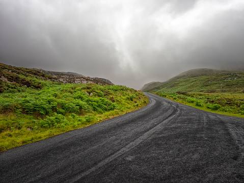Empty road cutting through rural Irish landscape near Urrismenagh, Roxtown, County Donegal, Ireland.