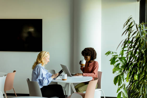 istock Joyful Office Coffee Break With Colleagues Sharing a Laugh in Bright Workspace 2129516620