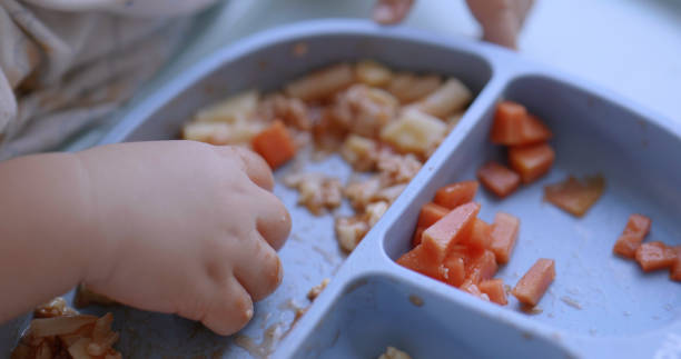 istock Asian boy eating food at home. Kid learning  using hand. 2129524216