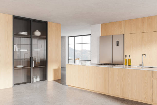 istock Wooden home kitchen interior with cooking cabinet, fridge and panoramic window 2129527933