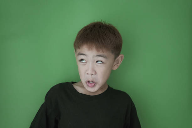 Close-up funny face Boy on Green wall