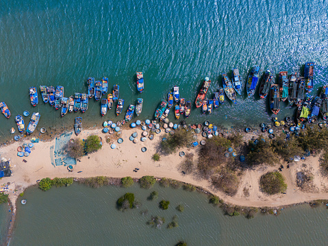 Aerial view of Loc An fishing village, Vung Tau city. A fishing port with tsunami protection concrete blocks. Cityscape and traditional boats in the sea. Travel and landscape concept