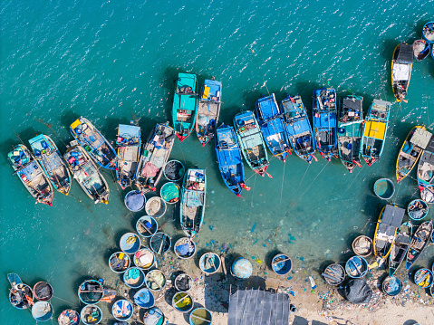 Aerial view of Loc An fishing village, Vung Tau city. A fishing port with tsunami protection concrete blocks. Cityscape and traditional boats in the sea. Travel and landscape concept