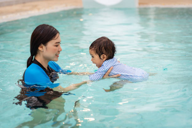 istock mother teaching her daughter swimming in pool 2129578263