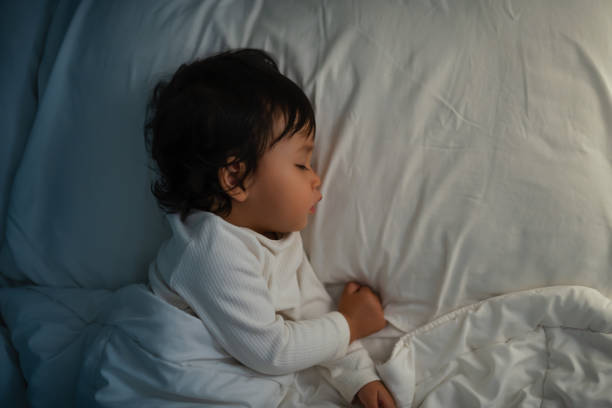 istock toddler baby sleeping on bed at night 2129578788