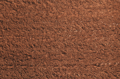 Top view of brown fertile agricultural soil, aerial shot from drone pov
