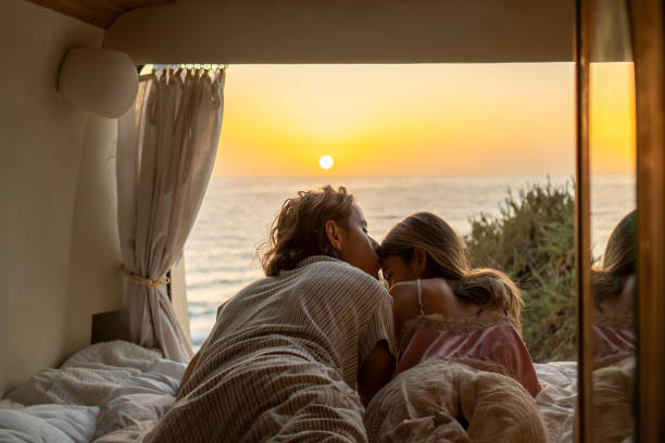 istock Happy couple lying on bed during sunset time 2129602826