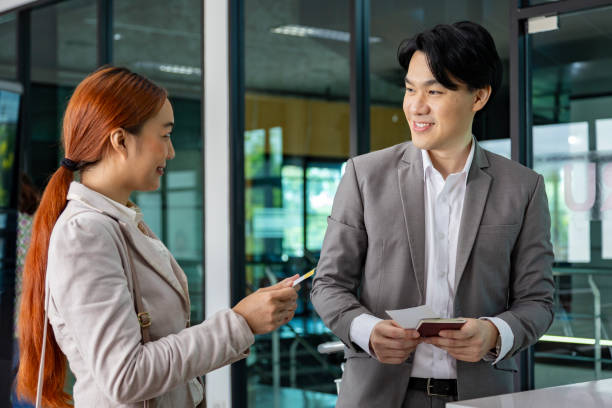 istock Couple passengers are getting their boarding pass from airline ground crew at departure gate into the airplane for final inspection before boarding the plane 2129609647