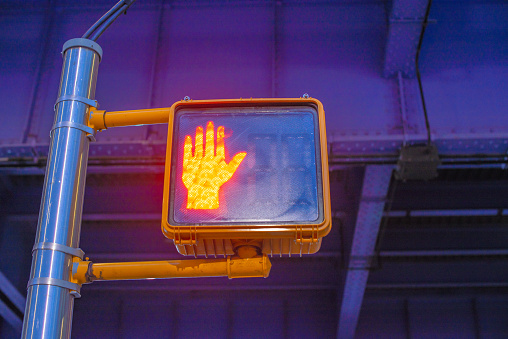 A sideways traffic light displaying a hand signal