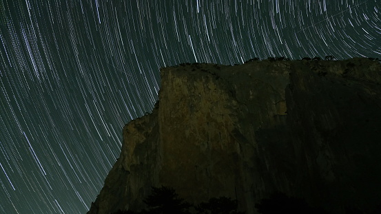 The night sky with many stars above a mountain