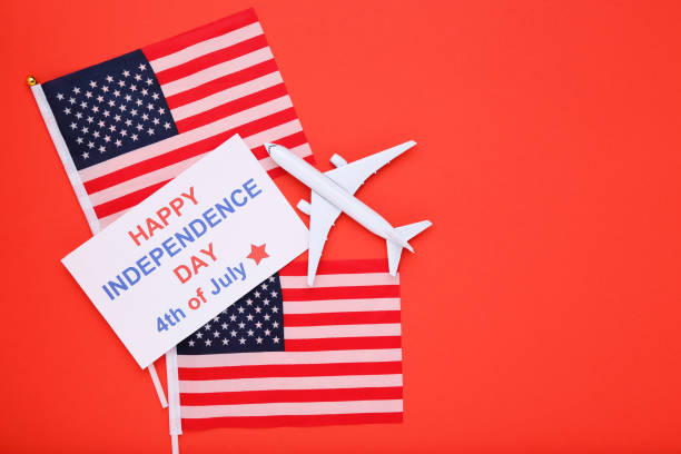 istock Text Happy Independence Day with flags and airplane model on red background 2129651650